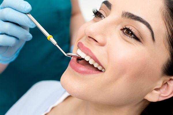 Smiling patient receiving exam with dental mirror in Salem, Or.